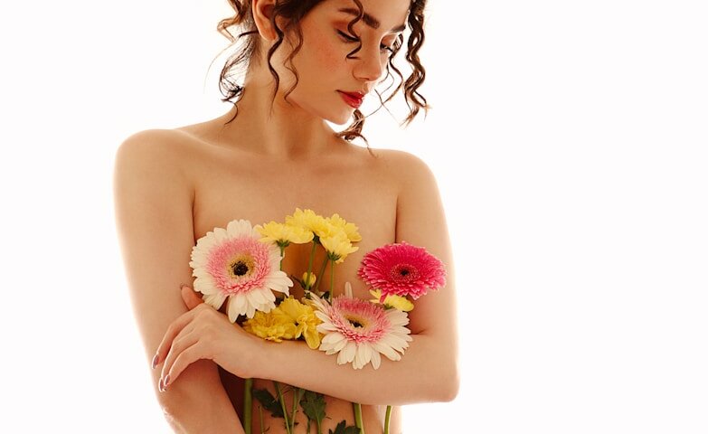 a woman with flowers in her hair holding a bouquet of flowers